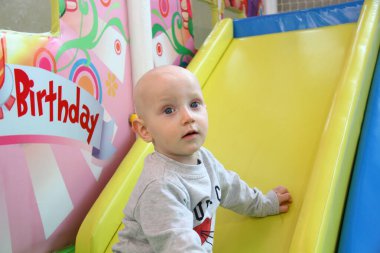 Güzel erkek bebek oyun alanında oynuyor.