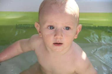 Güzel bir yıl erkek çocuğu yüzme havuzunda oynuyor