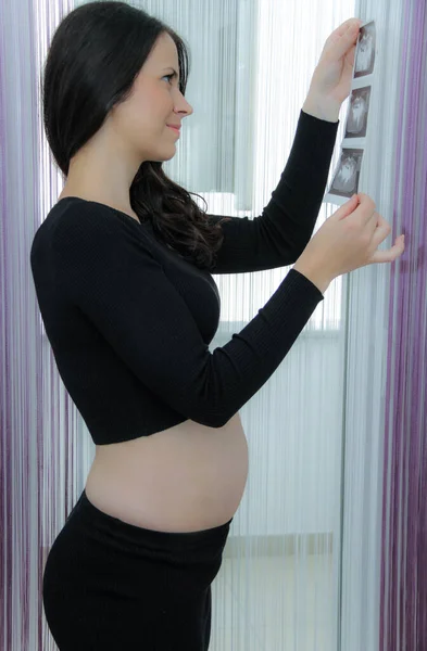 Mulher grávida feliz com barriga grande na janela, gravidez, mãe — Fotografia de Stock