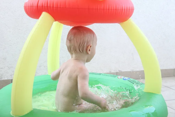 Bonito menino de um ano brincando na piscina — Fotografia de Stock