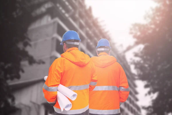 Två ingenjörer tittar på byggarbetsplatsen — Stockfoto