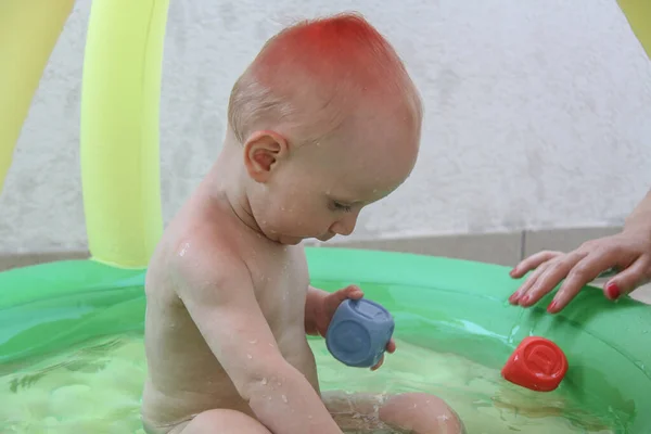 Schöner einjähriger Junge spielt im Schwimmbad — Stockfoto