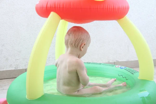Bonito menino de um ano brincando na piscina — Fotografia de Stock