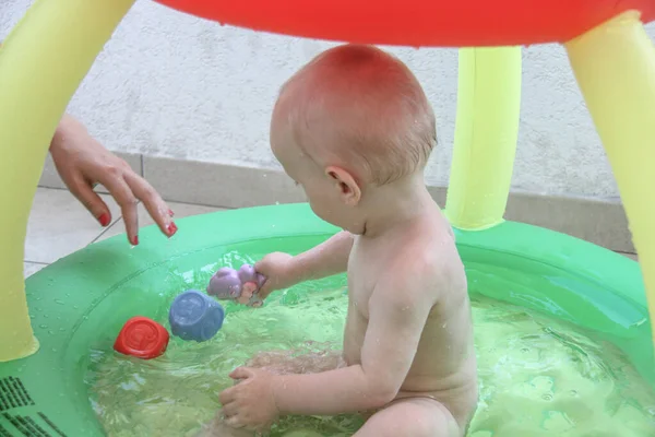 Schöner einjähriger Junge spielt im Schwimmbad — Stockfoto