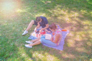 Aşık mutlu çift, parkta dinleniyor ve günün tadını çıkarıyor.