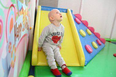 Güzel erkek bebek oyun alanında oynuyor.