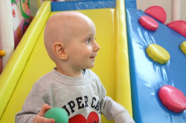 Güzel erkek bebek oyun alanında oynuyor.