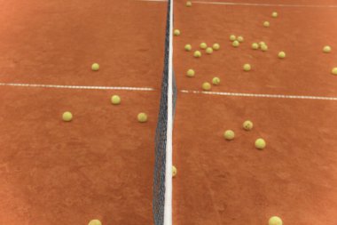 Kırmızı sahada gri ağlı tenis topları