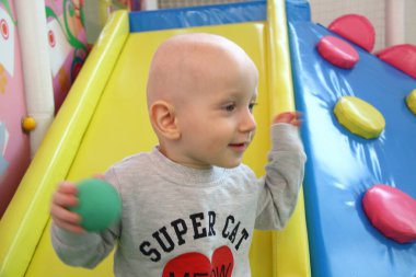 Güzel erkek bebek oyun alanında oynuyor.