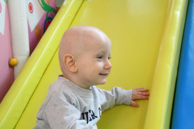 Güzel erkek bebek oyun alanında oynuyor.