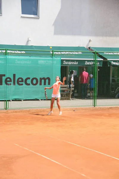 Krásná mladá dívka na otevřeném tenisovém kurtu hrát tenis — Stock fotografie