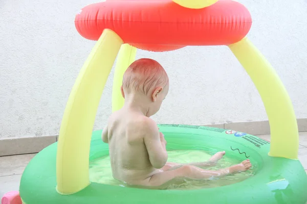 Schöner einjähriger Junge spielt im Schwimmbad — Stockfoto