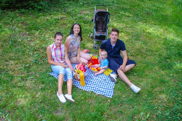 Glückliche Familie beim Picknick im grünen Park — Stockfoto