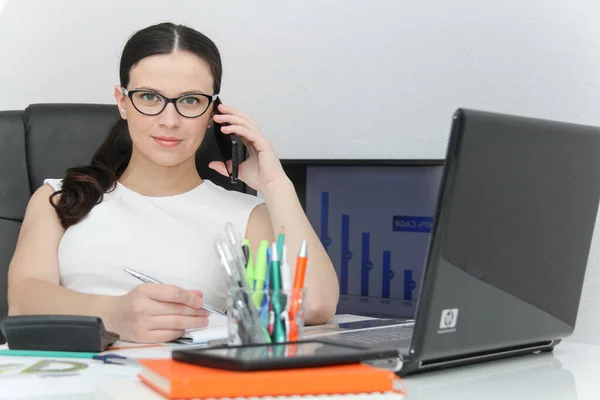 Attraktiv kvinna använda smart företagstelefon och sitter på hennes wor — Stockfoto
