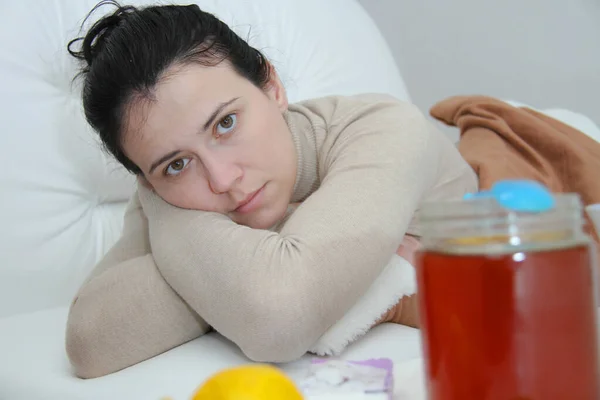 Mujer enferma joven acostada en la cama — Foto de Stock