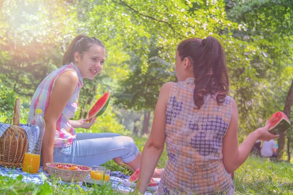 Zwei junge Frauen genießen das Gespräch und essen Wassermelone — Stockfoto