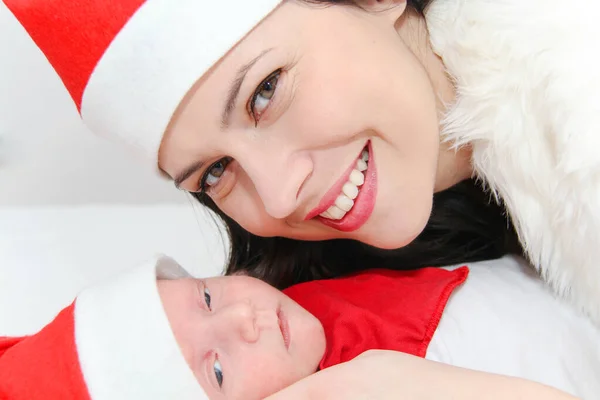 Šťastná matka s mužem dítě nosí vánoční klobouky — Stock fotografie
