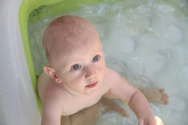 Schöner einjähriger Junge spielt im Schwimmbad — Stockfoto