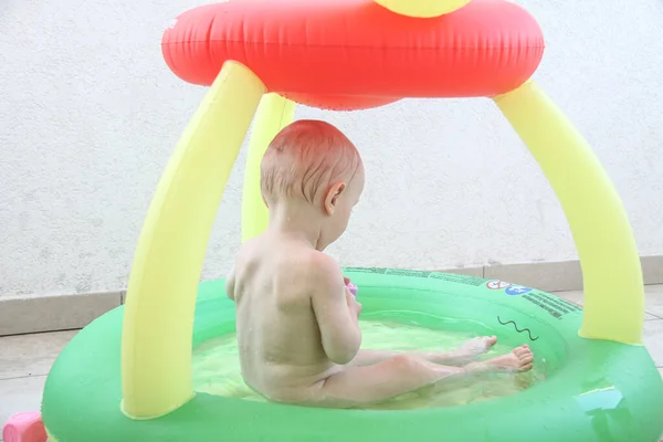 Beautiful one year baby boy playing in the swimming pool — 스톡 사진