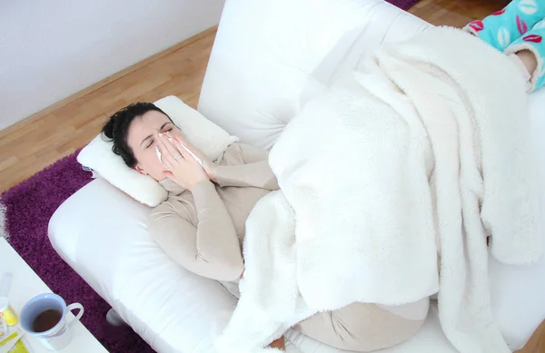 Jonge zieke vrouw liggend in bed — Stockfoto
