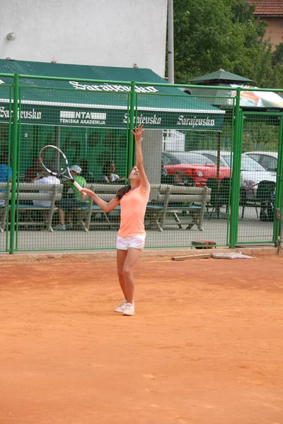 Beautiful young girl on open tennis court playing tennis — Stockfoto