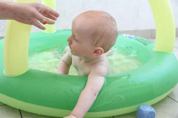 Schöner einjähriger Junge spielt im Schwimmbad — Stockfoto