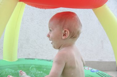 Güzel erkek bebek oyun alanında oynuyor.