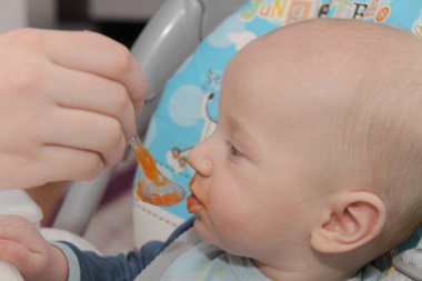 Genç anne oğlunu evde besliyor.