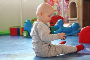 Güzel erkek bebek oyun alanında oynuyor.