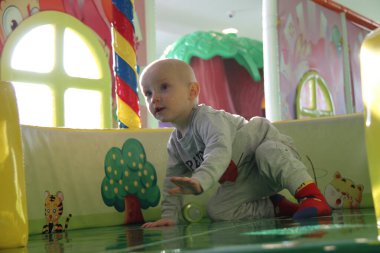 Güzel erkek bebek oyun alanında oynuyor.