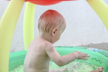 Bir yaşında erkek bebek yatakta oynuyor.