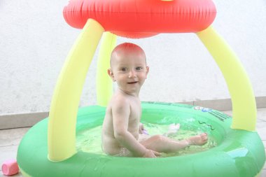 Bir yaşında erkek bebek yatakta oynuyor.