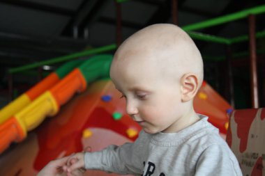 Güzel erkek bebek oyun alanında oynuyor.