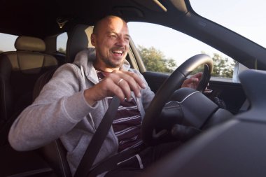 Araba süren bir adam. Başarı devrede. Yakışıklı genç adam araba kullanıyor.