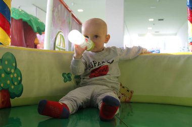 Güzel erkek bebek oyun alanında oynuyor.