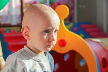 Güzel erkek bebek oyun alanında oynuyor.