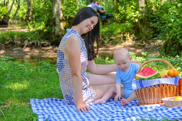 Jolie mère avec bébé s'amusant au pique-nique dans le parc — Photo