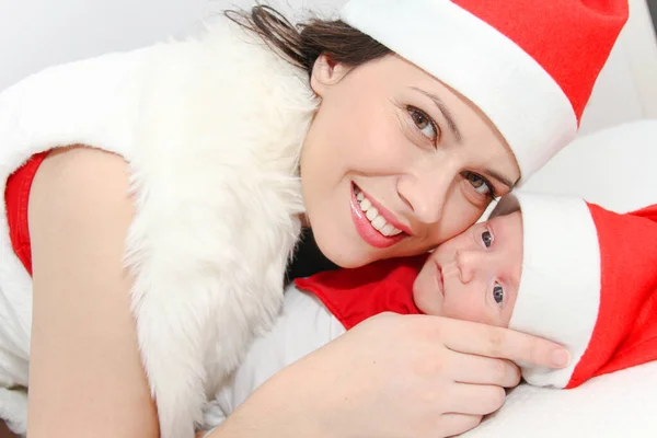 Šťastná matka s mužem dítě nosí vánoční klobouky — Stock fotografie