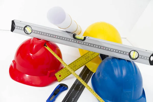 Colorful helmets and tools for construction drawings and buildin — Stock Photo, Image