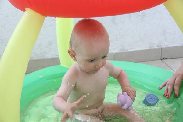 Красивий однорічний хлопчик грає у басейні — стокове фото