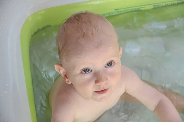 Schöner einjähriger Junge spielt im Schwimmbad — Stockfoto