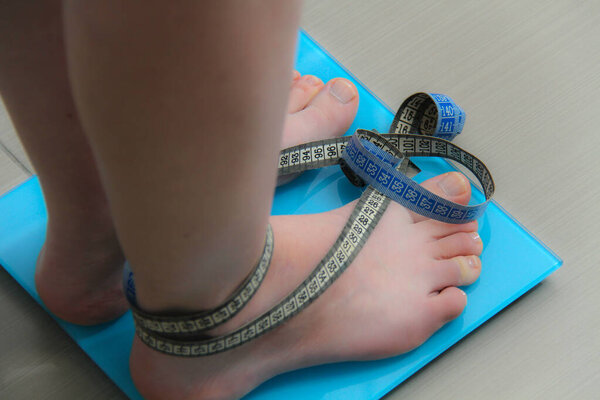 Female legs, Legs of woman standing on scales weight. Concept of