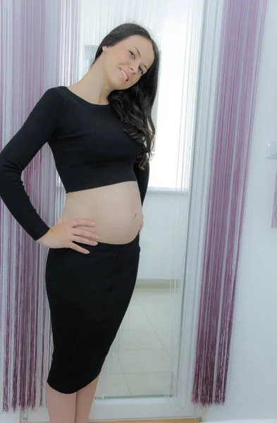 Heureuse femme enceinte avec gros ventre à la fenêtre, grossesse, mère — Photo