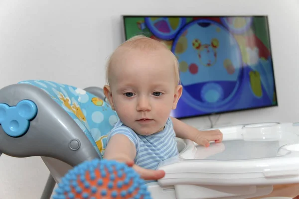 Ein Jahr Baby schaut Zeichentrickfilme im Fernsehen und spielt — Stockfoto