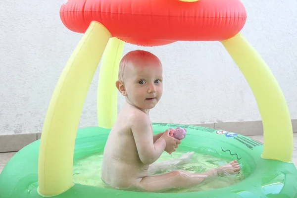Beautiful one year baby boy playing in the swimming pool — 스톡 사진