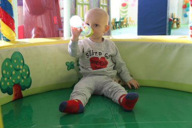 Güzel erkek bebek oyun alanında oynuyor.