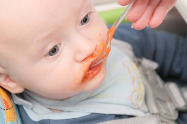 Genç anne oğlunu evde besliyor.