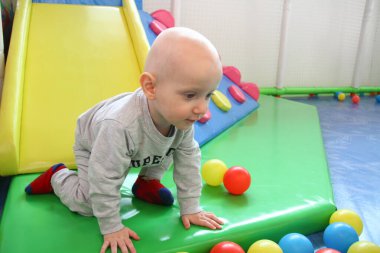 Güzel erkek bebek oyun alanında oynuyor.