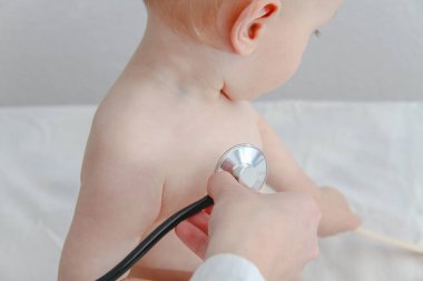 One year old sick baby boy at the young female doctor