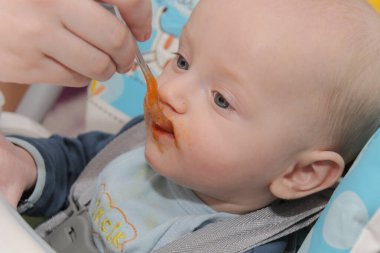 Genç anne oğlunu evde besliyor.